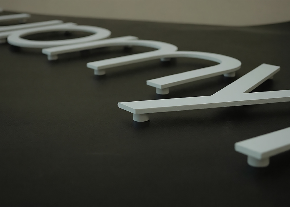 Торцы акриловой 2D-буквы шлифуют для удаления неровностей и заусенцев, оставшихся после резки, делая кромку гладкой и безопасной. Шлифовка придает торцу прозрачность, позволяя свету проходить через него.